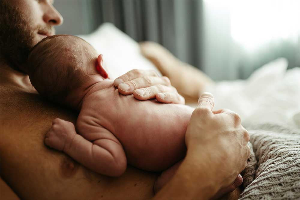Ett barn som ligger på sin pappas bröstkorg