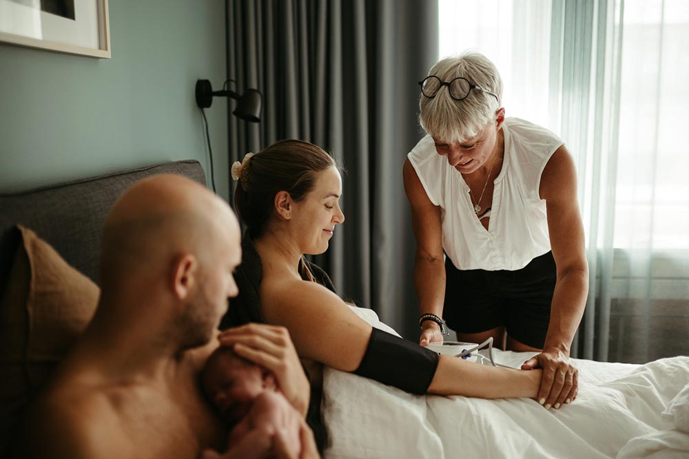 Checking blood pressure of new mother