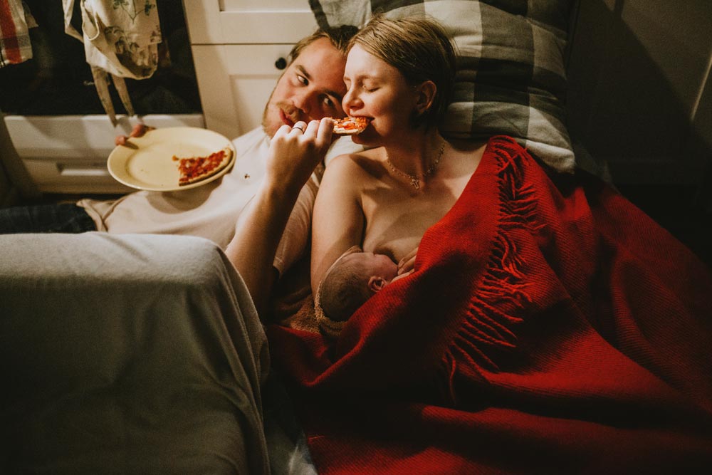Couple eating pizza after childbirth